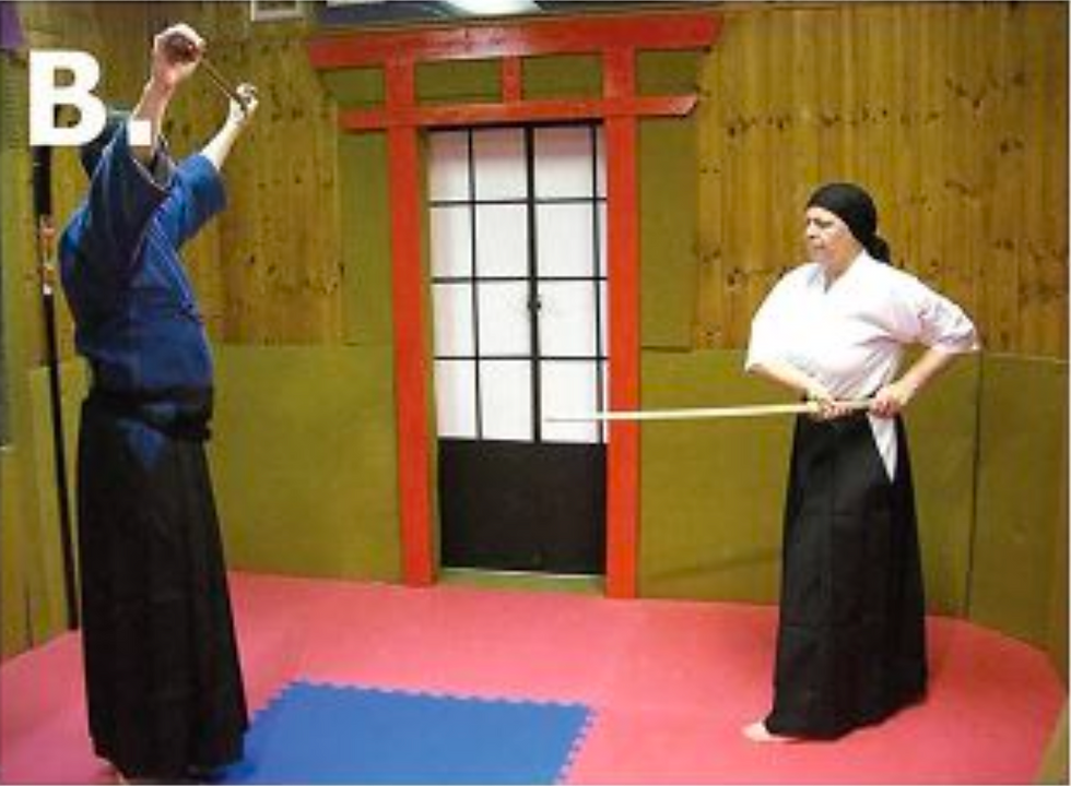 B. The opponent draws her bokken to her left hip in preparation for a thrust.