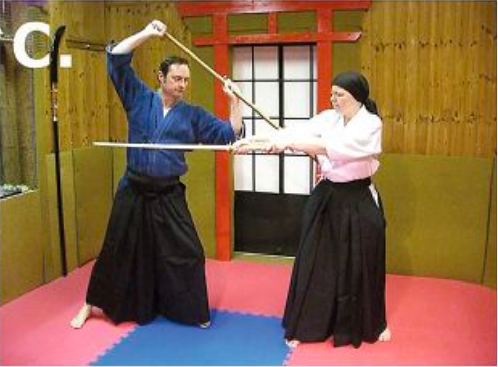 C. The jo practitioner moves to the left to avoid the thrust and places the tip of the jo against the opponent’s left side, wedging the attack.
