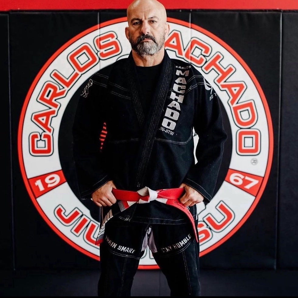 Carlos Machado stands in front of his school's sign