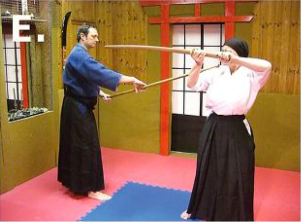 E. The jo practitioner advances and slides his weapon toward the opponent’s right shoulder.