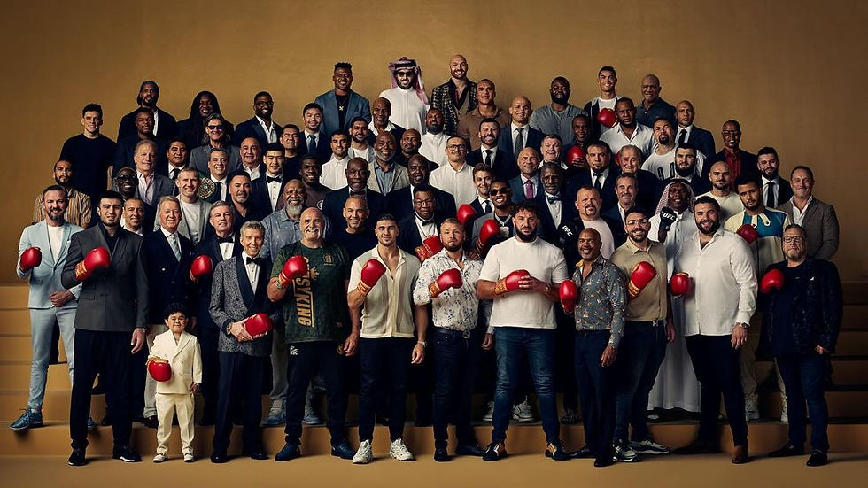 A diverse group of people holding red boxing gloves stands on steps. The background is a warm, yellowish tone. The mood is celebratory.