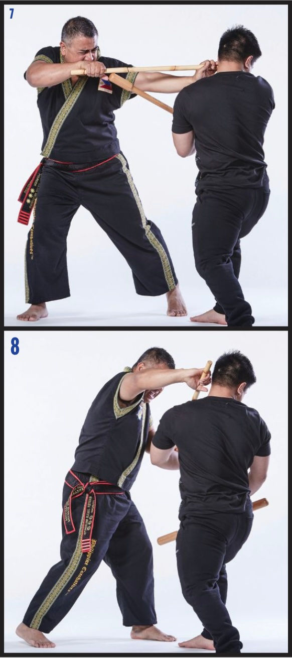 Two men in martial arts uniforms practice stick fighting. The man on the left actively engages, wearing a black outfit with gold trim.