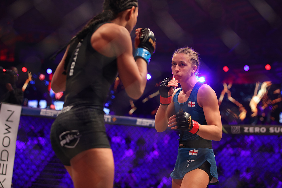 Two female fighters in a cage match, one in black, the other in blue with England flag. Intense focus, purple-lit arena background.