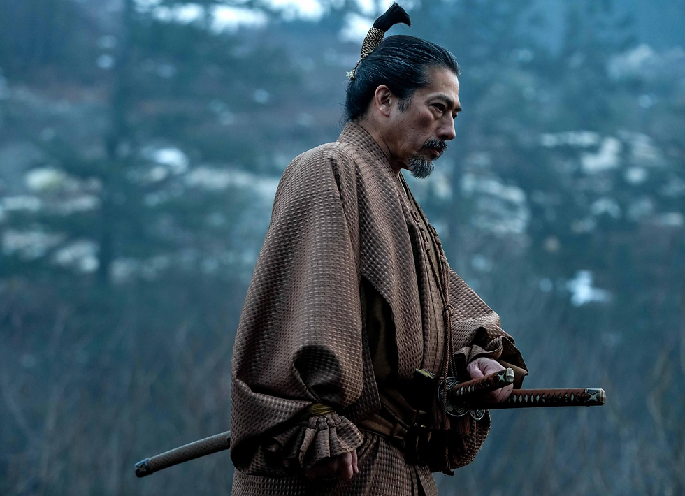 Samurai in a brown patterned kimono holds a katana outdoors. The background features a misty forest, creating a contemplative mood.