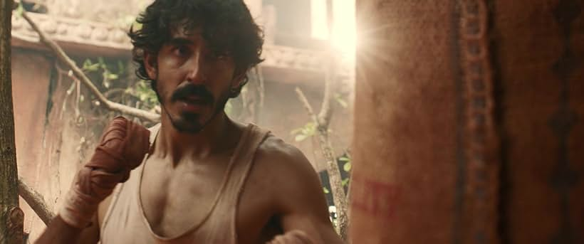 Man boxing with focus and intensity. Sunlit outdoor setting with trees and rustic walls. Warm colors create a determined mood.