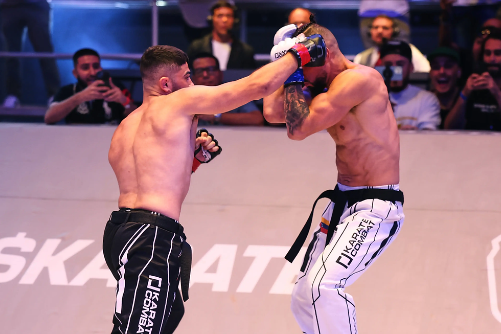 Two shirtless fighters in a karate match, one punching the other. Audience in the background. "Karate Combat" text on pants.