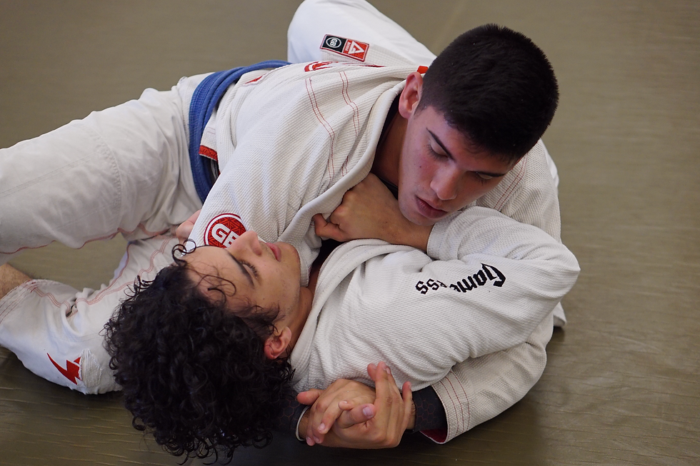 Two BJJ practitioners grapple on the floor