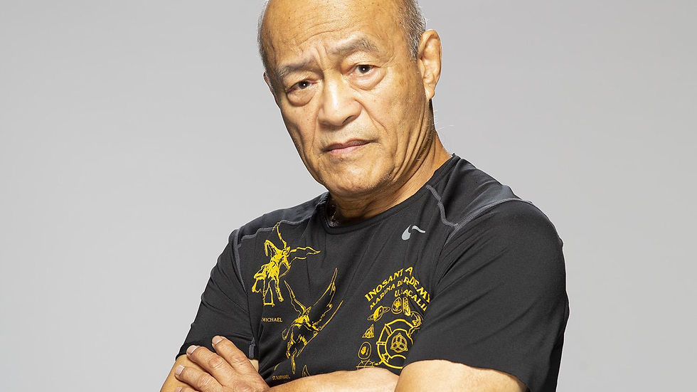 Dan Inosanto poses with folded arms